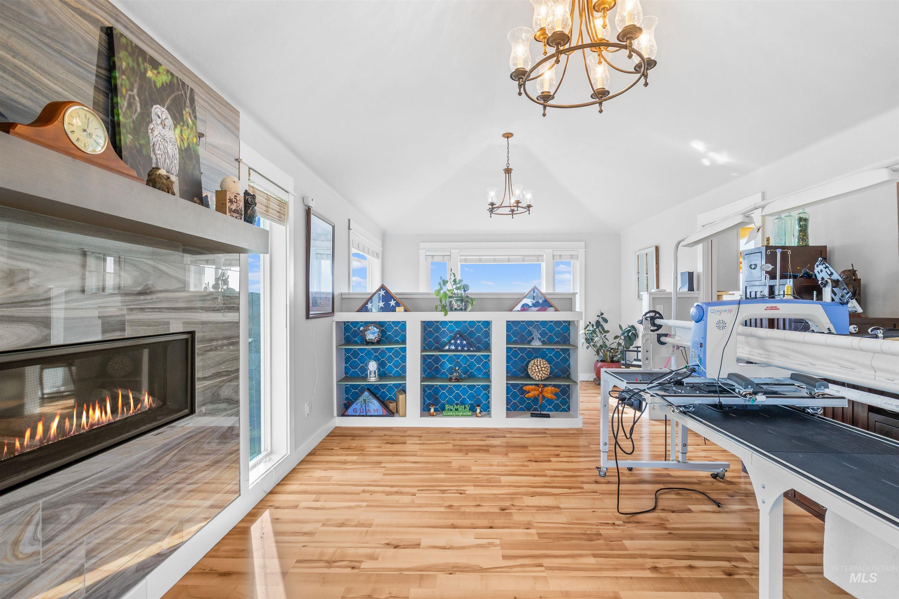 2435 Arborcrest Road Moscow, ID 83843 - Photo 13 of 48 Office area with lofted ceiling, hanging lights, light wood-style floors, and a fireplace