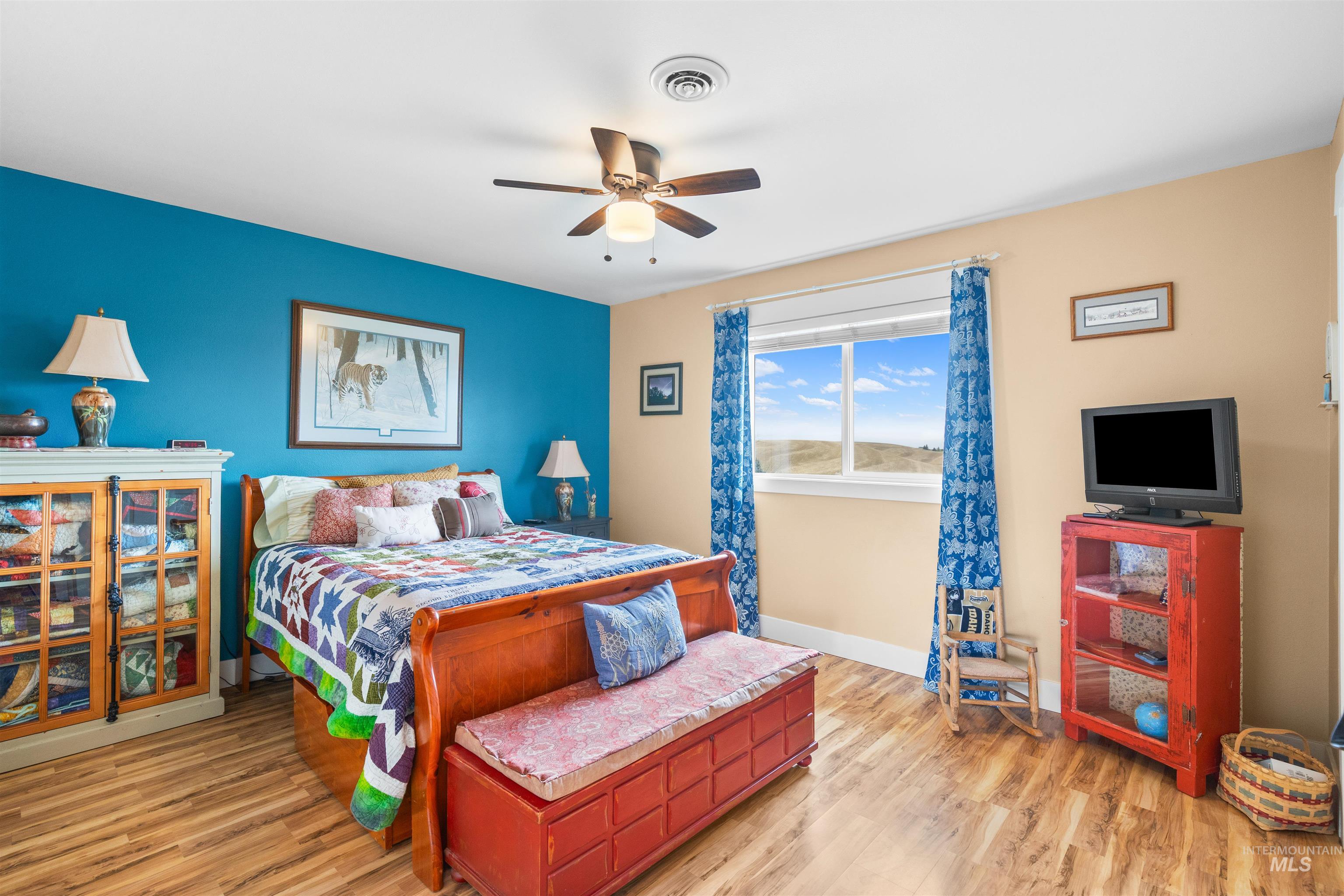 2435 Arborcrest Road Moscow, ID 83843 - Photo 23 of 48 Bedroom featuring light wood-type flooring, a ceiling fan, and an accent wall
