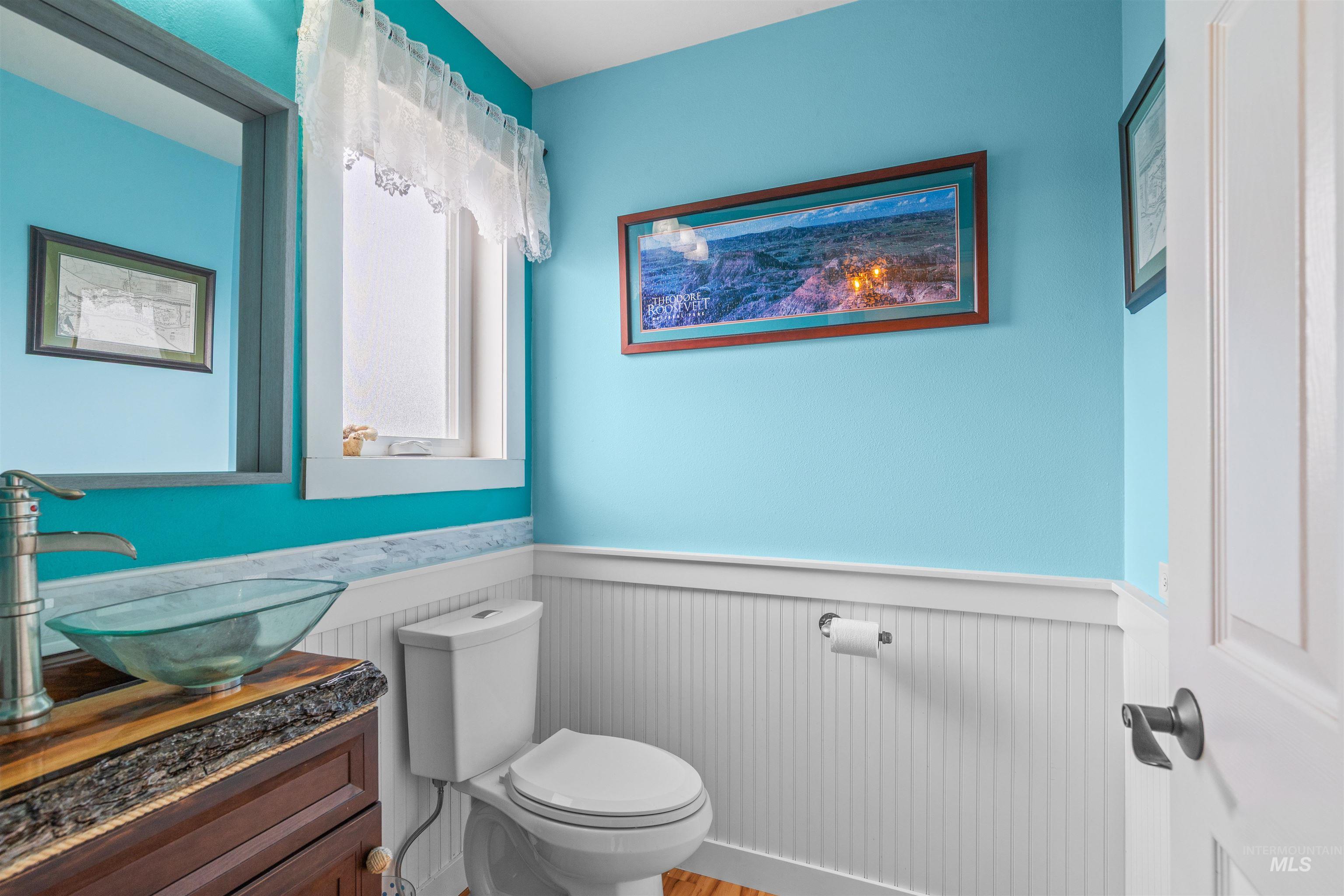 2435 Arborcrest Road Moscow, ID 83843 - Photo 27 of 48 Half bathroom with vanity, wood finished floors, and a wainscoted wall