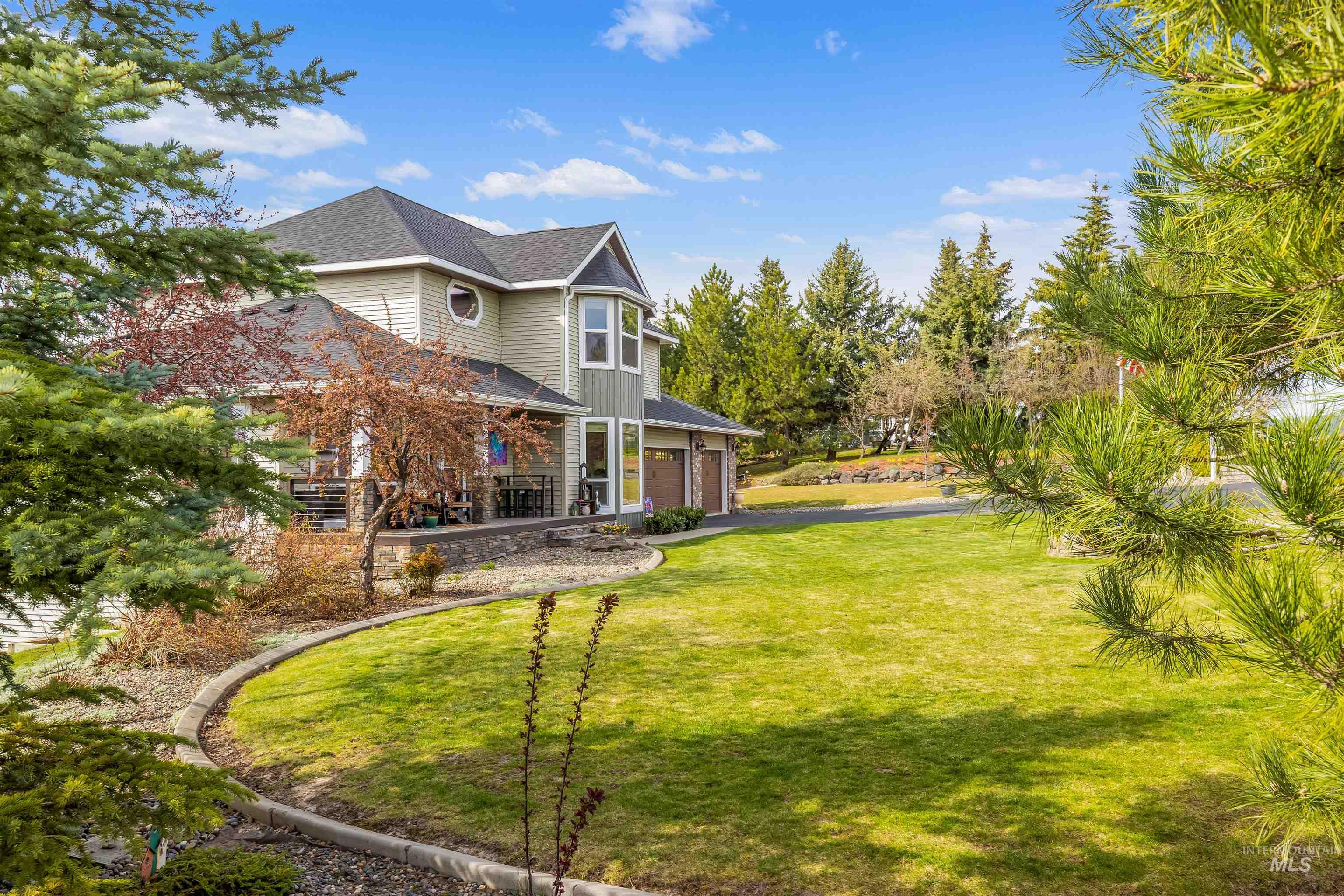 2435 Arborcrest Road Moscow, ID 83843 - Photo 37 of 48 View of grassy yard with a garage, driveway, and covered porch