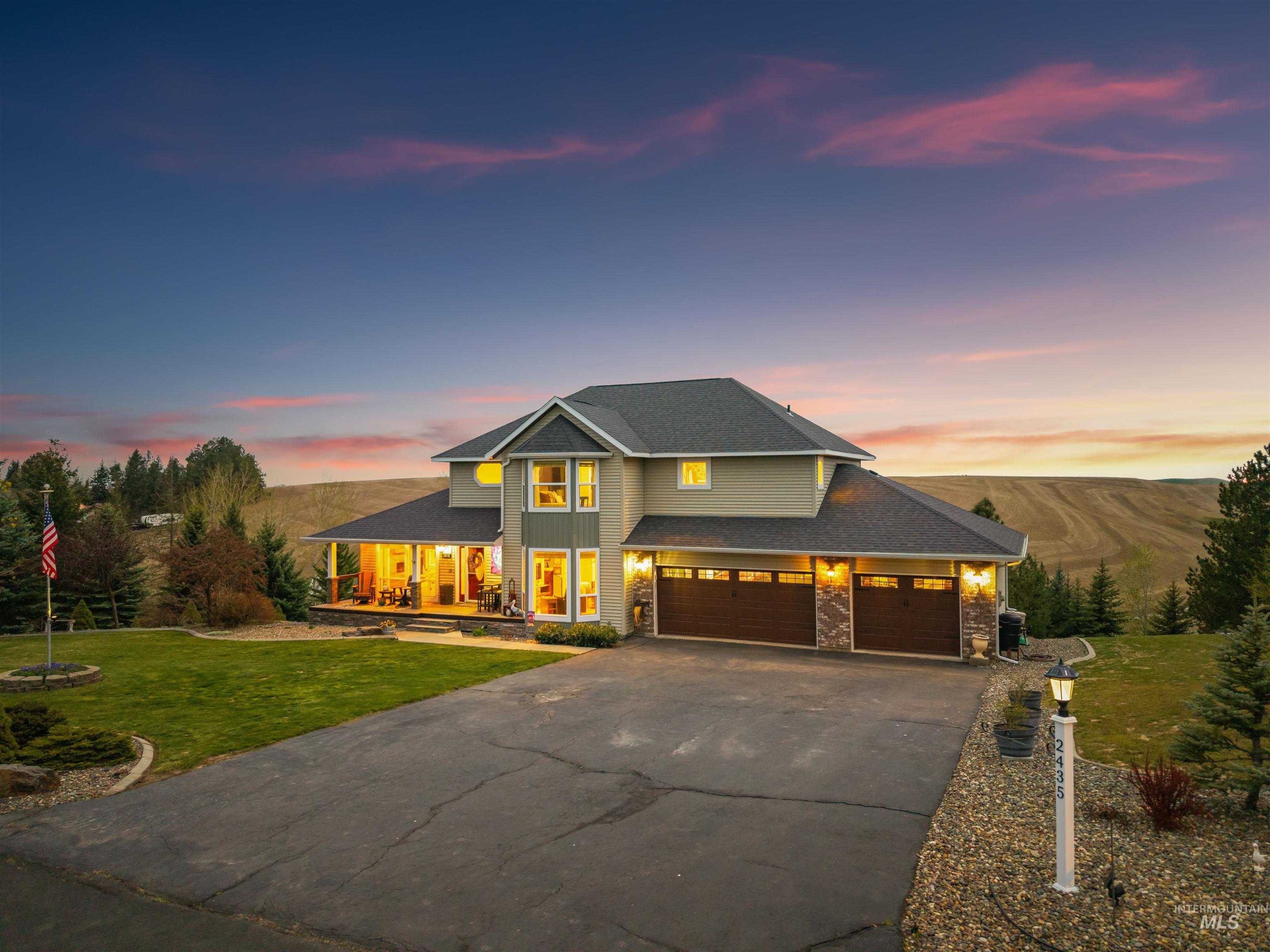 2435 Arborcrest Road Moscow, ID 83843 - Photo 43 of 48 View of front of home featuring a lawn, asphalt driveway, stone siding, roof with shingles, and a garage