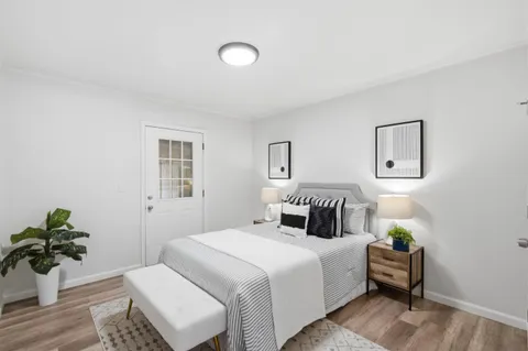 a bedroom with a bed and a potted plant