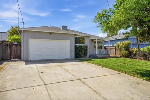a front view of a house with a garden and yard