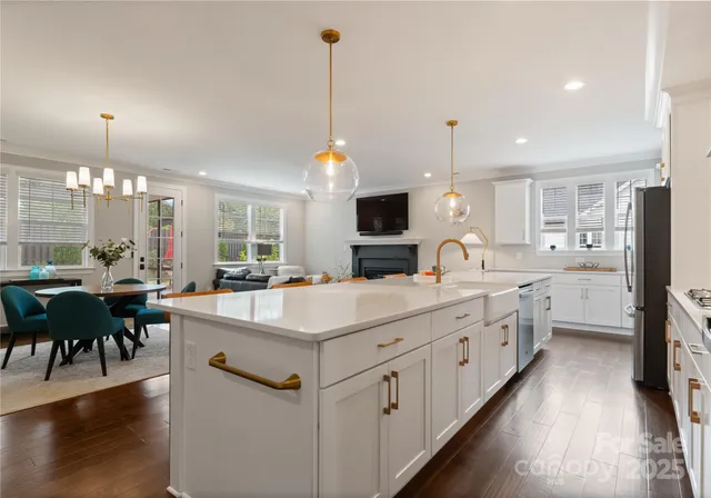 a large white kitchen with lots of counter space dining table and chairs