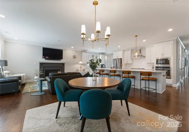a dining room with furniture a chandelier and wooden floor