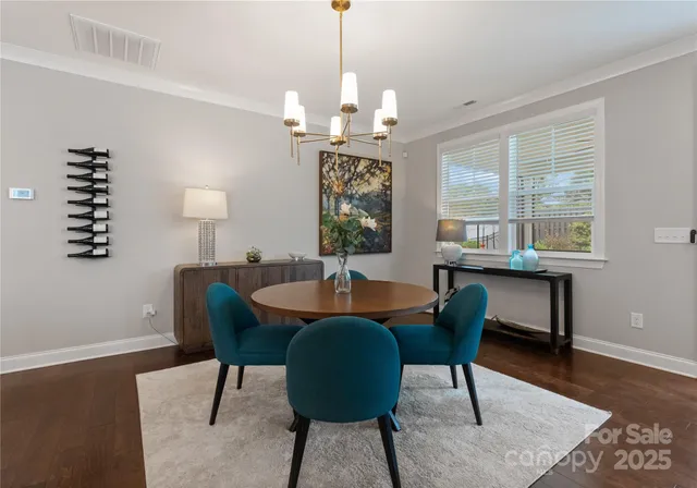 a dining room with furniture a chandelier and wooden floor