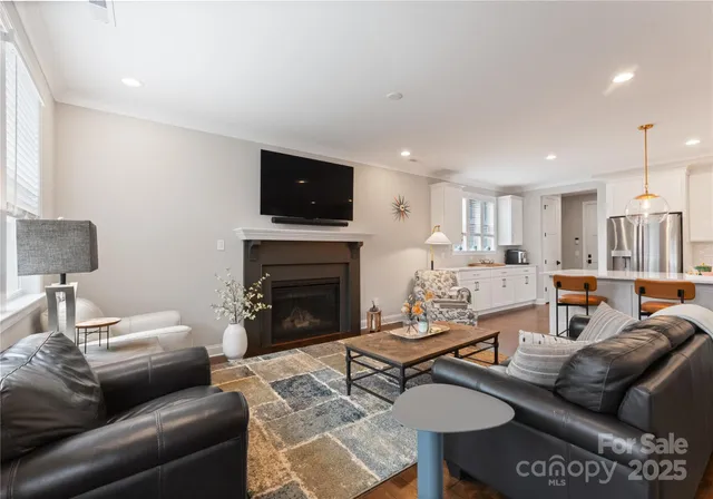 a living room with furniture a flat screen tv and a fireplace