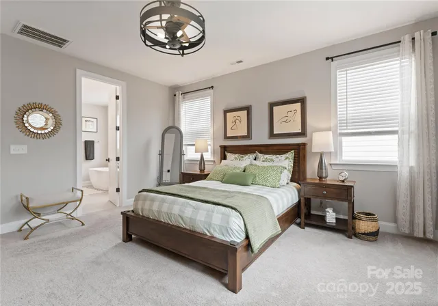 a spacious bedroom with a bed mirror and a window