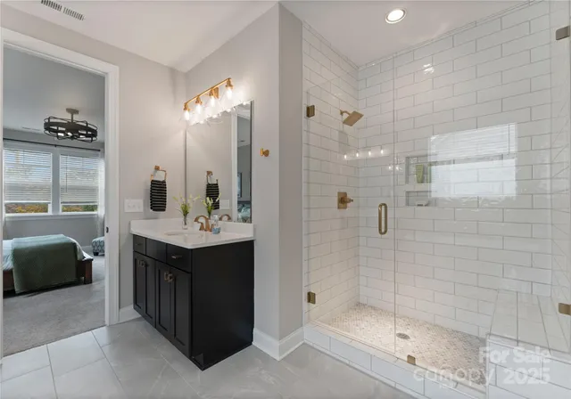 a bathroom with a double vanity sink mirror and shower