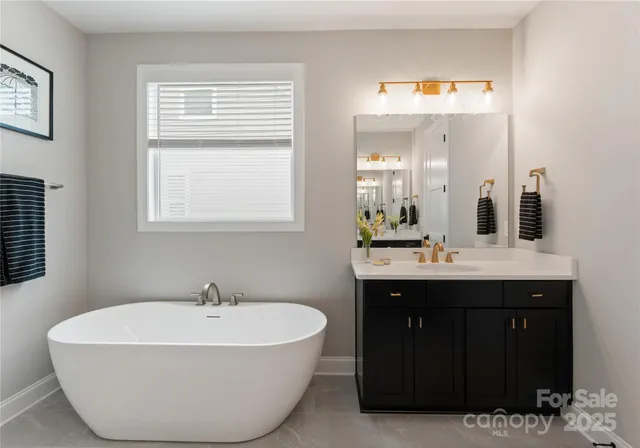 a spacious bathroom with a tub sink and mirror