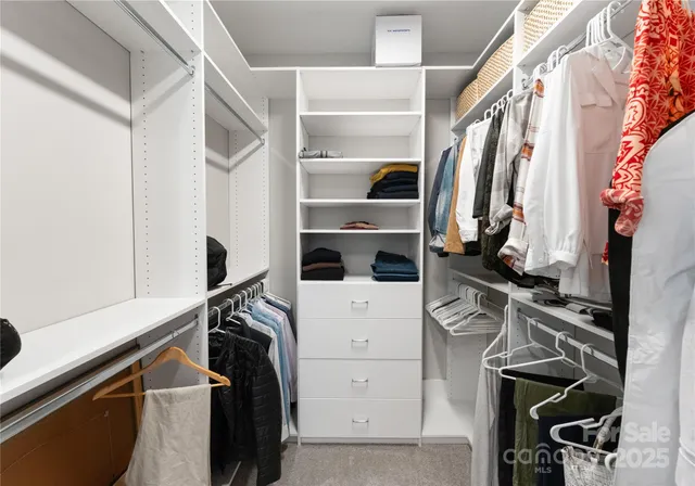 a view of walk in closet with clothes and shoes