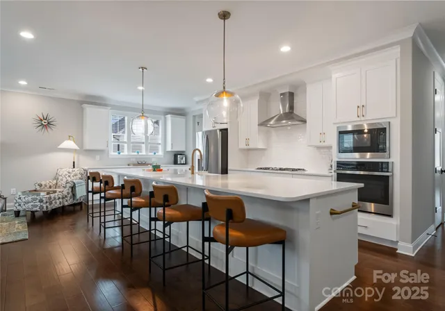 a kitchen with stainless steel appliances granite countertop a kitchen island a stove a table and chairs in it