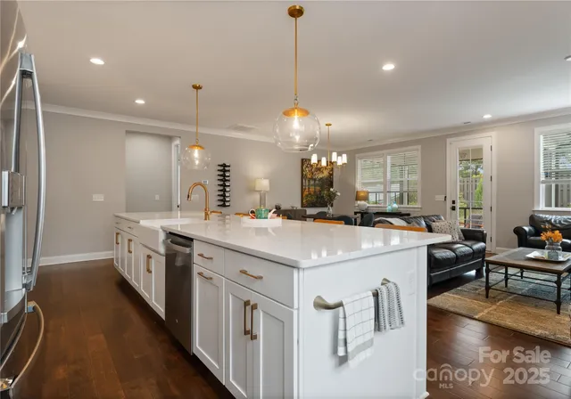 a large kitchen with kitchen island a stove a sink a dining table and chairs with wooden floor
