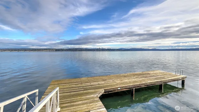 a kitchen with stainless steel appliances a sink a stove a refrigerator cabinets and living room view
