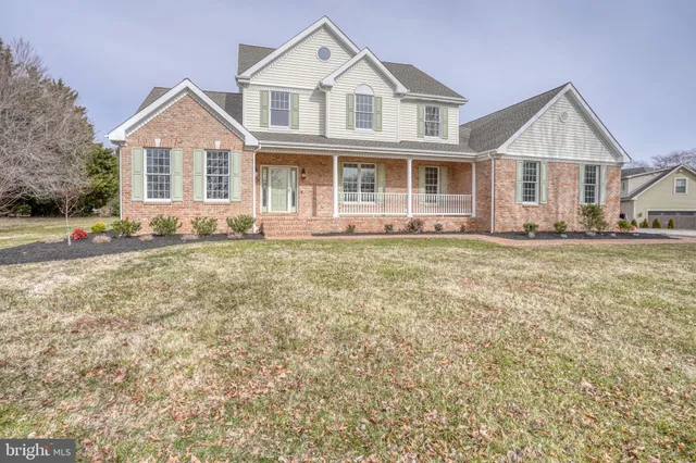 a view of a room with wooden floor chandelier and windows