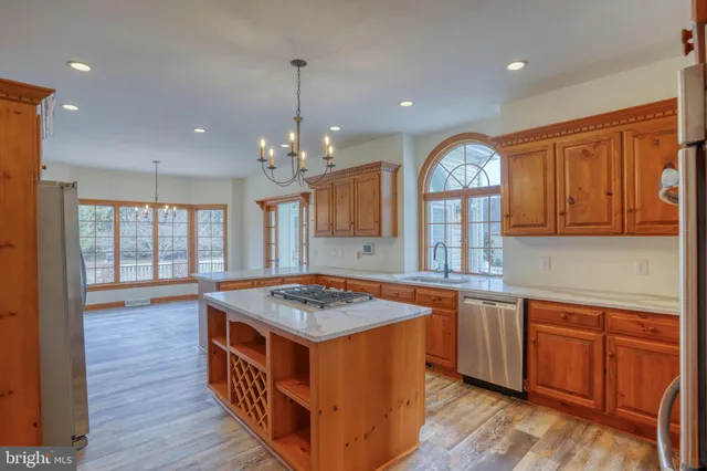 a kitchen with stainless steel appliances granite countertop a sink a stove and a wooden floors