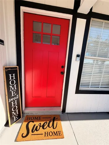 a view of front door with a red door and a window