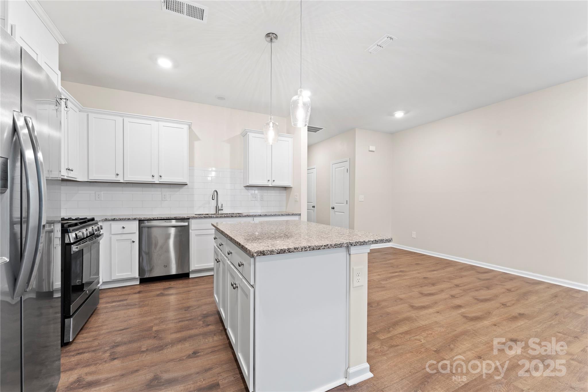 5215 Maynard Hl Drive Monroe, NC 28110 - Photo 9 of 34 a kitchen with stainless steel appliances granite countertop a sink a stove and a refrigerator