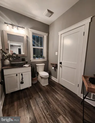 a spacious bathroom with a double vanity sink a toilet and a mirror