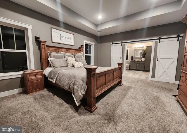 a bedroom with a bed lamp and a large window