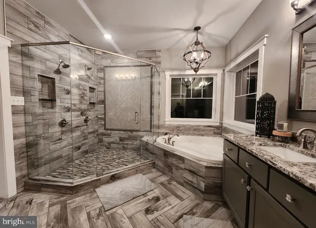 a bathroom with a granite countertop sink a large mirror and shower