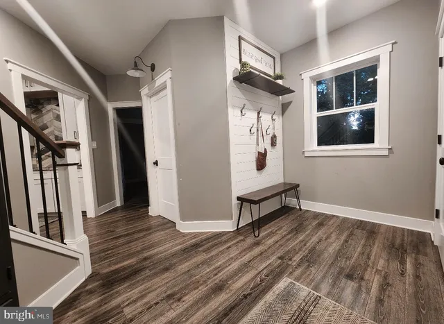 a view of an entryway with wooden floor and door