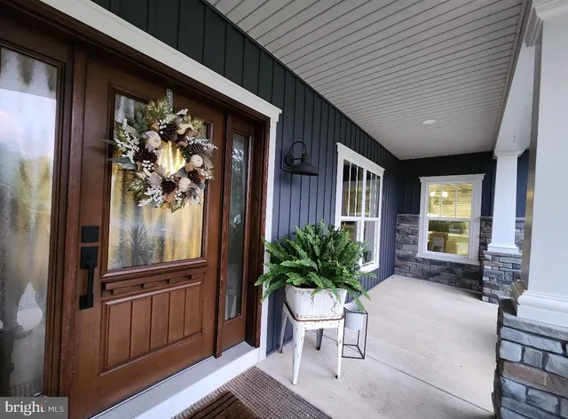 a view of a porch with chairs and potted plants