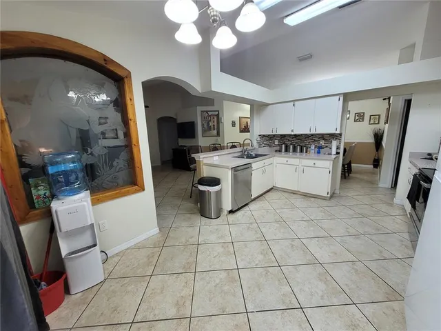 a kitchen with white cabinets a sink and white appliances