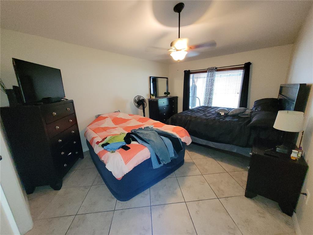 4233 Amber Ridge Lane Valrico, FL 33594 - Photo 21 of 40 a bedroom with a bed and a flat tv screen on dresser