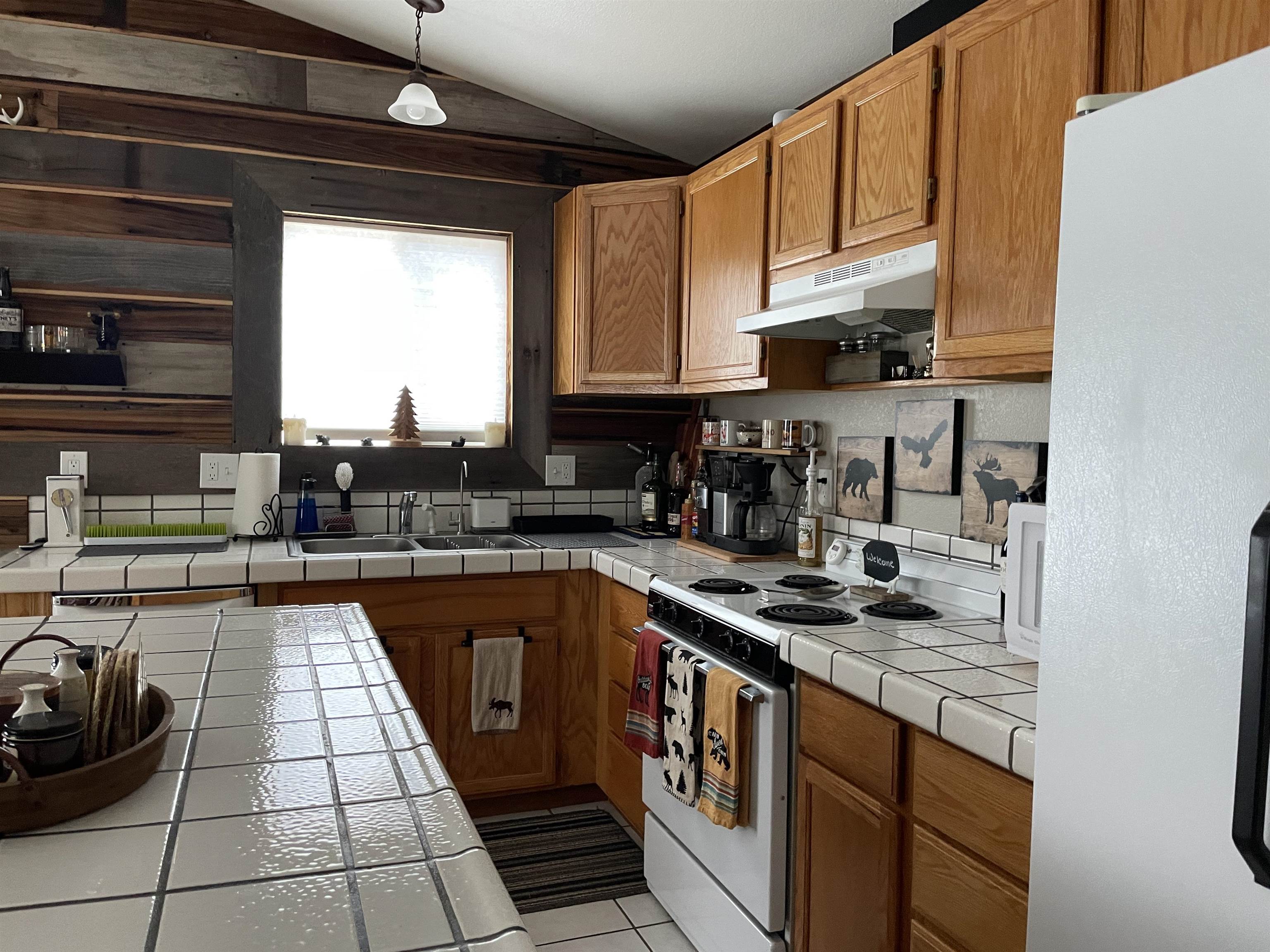 1154 Rocky Cliff Road Portola, CA 96122 - Photo 5 of 15 a kitchen with stainless steel appliances granite countertop a sink stove and cabinets