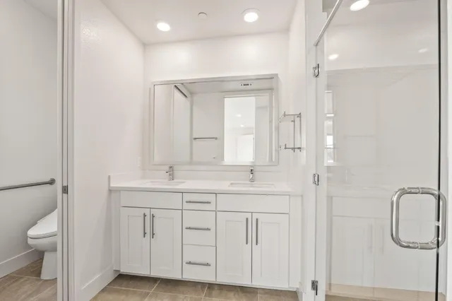 a bathroom with a shower sink vanity and mirror