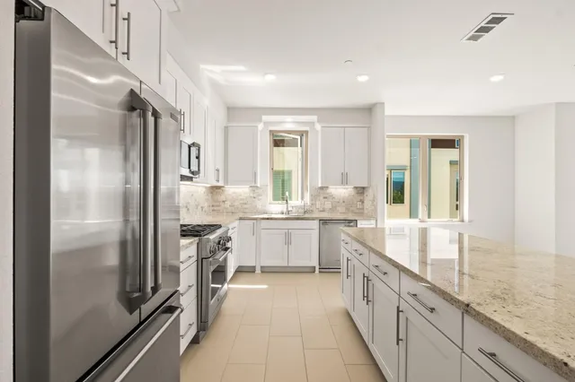 a large kitchen with a large window and stainless steel appliances