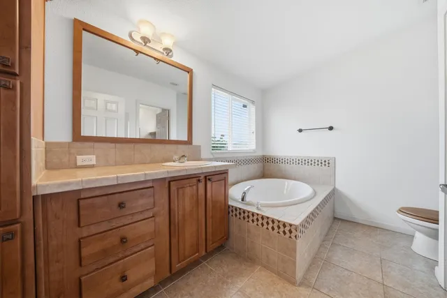 a bathroom with a granite countertop sink toilet mirror and a