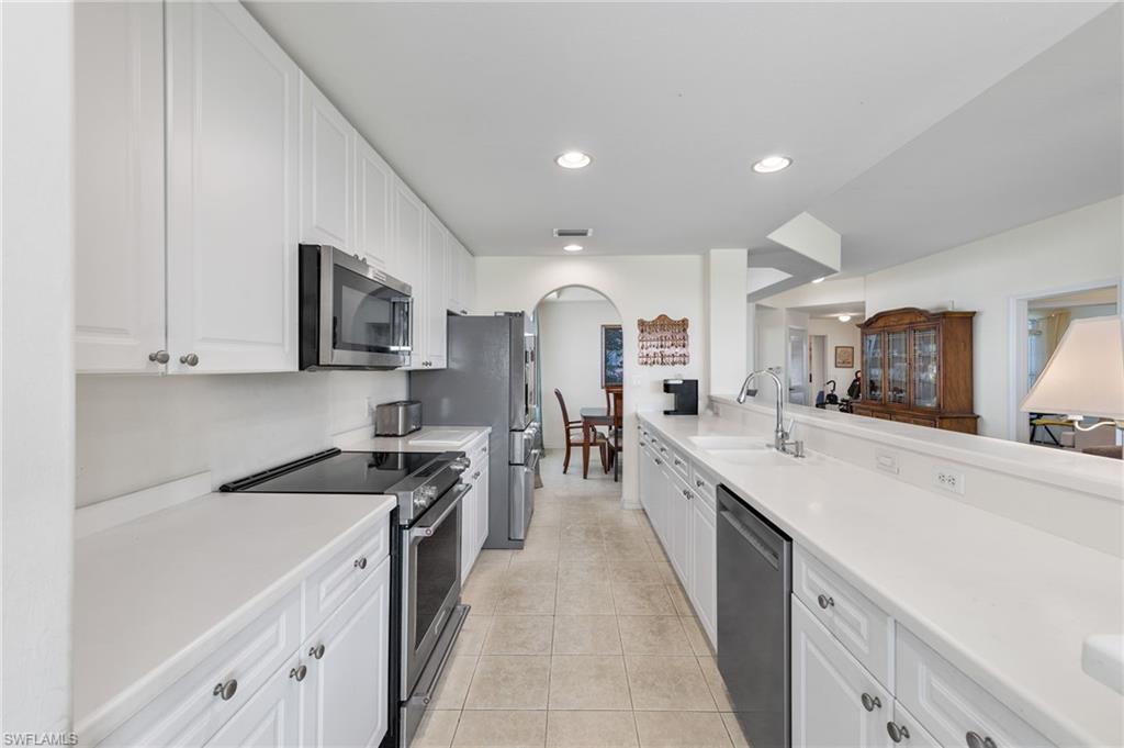 1953 Crestview Way, Unit 161 Naples, FL 34119 - Photo 12 of 37 a large kitchen with stainless steel appliances granite countertop a lot of counter space and wooden floors