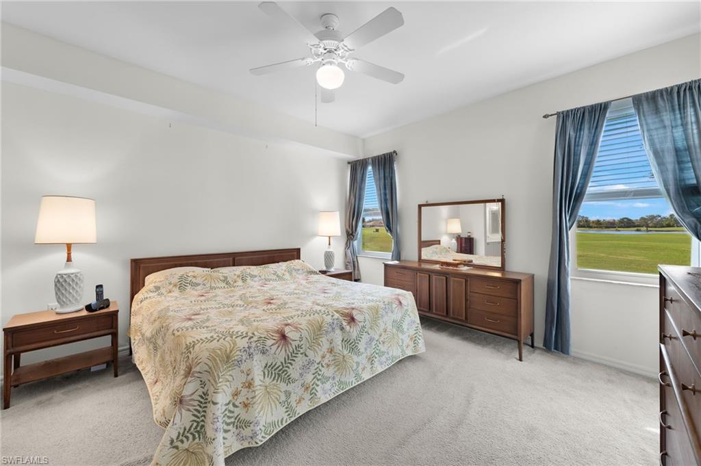 1953 Crestview Way, Unit 161 Naples, FL 34119 - Photo 15 of 37 a bedroom with a bed and a chandelier
