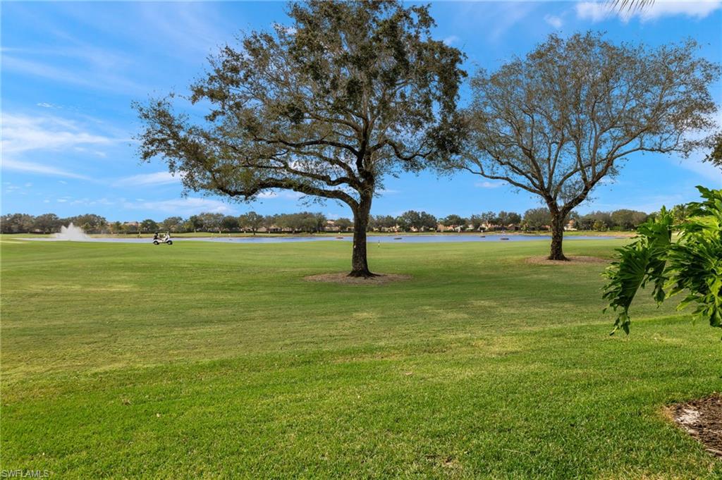1953 Crestview Way, Unit 161 Naples, FL 34119 - Photo 27 of 37 a view of outdoor space with green field and trees