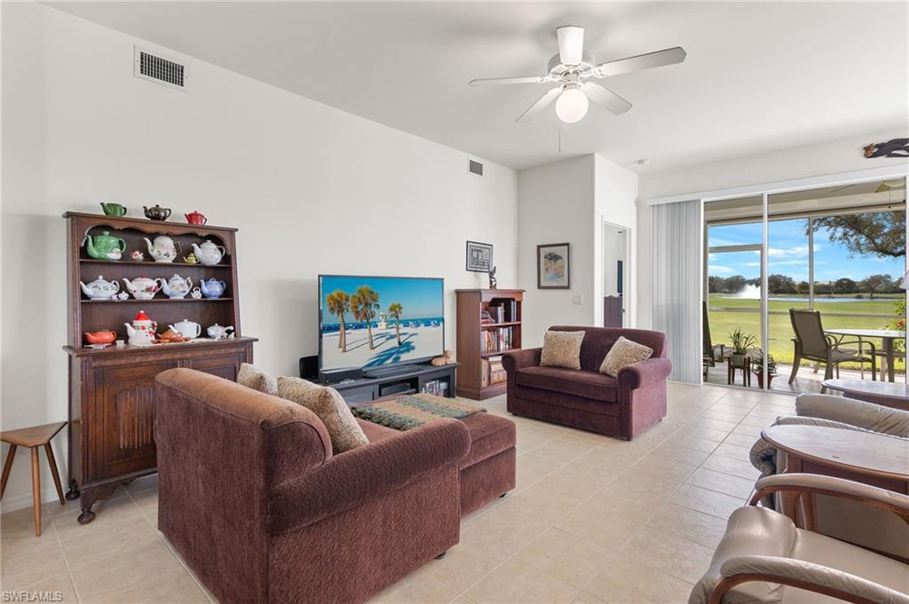 1953 Crestview Way, Unit 161 Naples, FL 34119 - Photo 8 of 37 a living room with furniture a fireplace and a large window