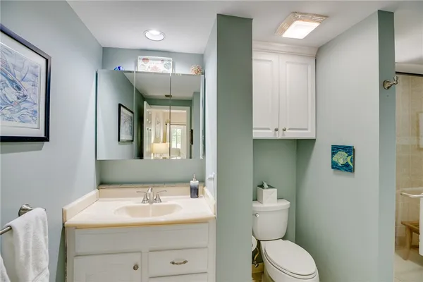 a bathroom with a toilet a sink and mirror