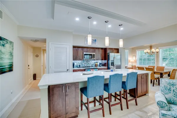 a dining room with stainless steel appliances kitchen island granite countertop a table and chairs