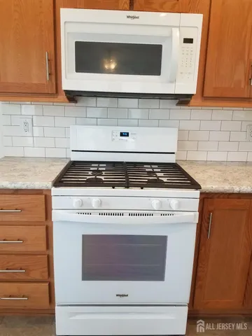 a stove top oven sitting inside of a kitchen