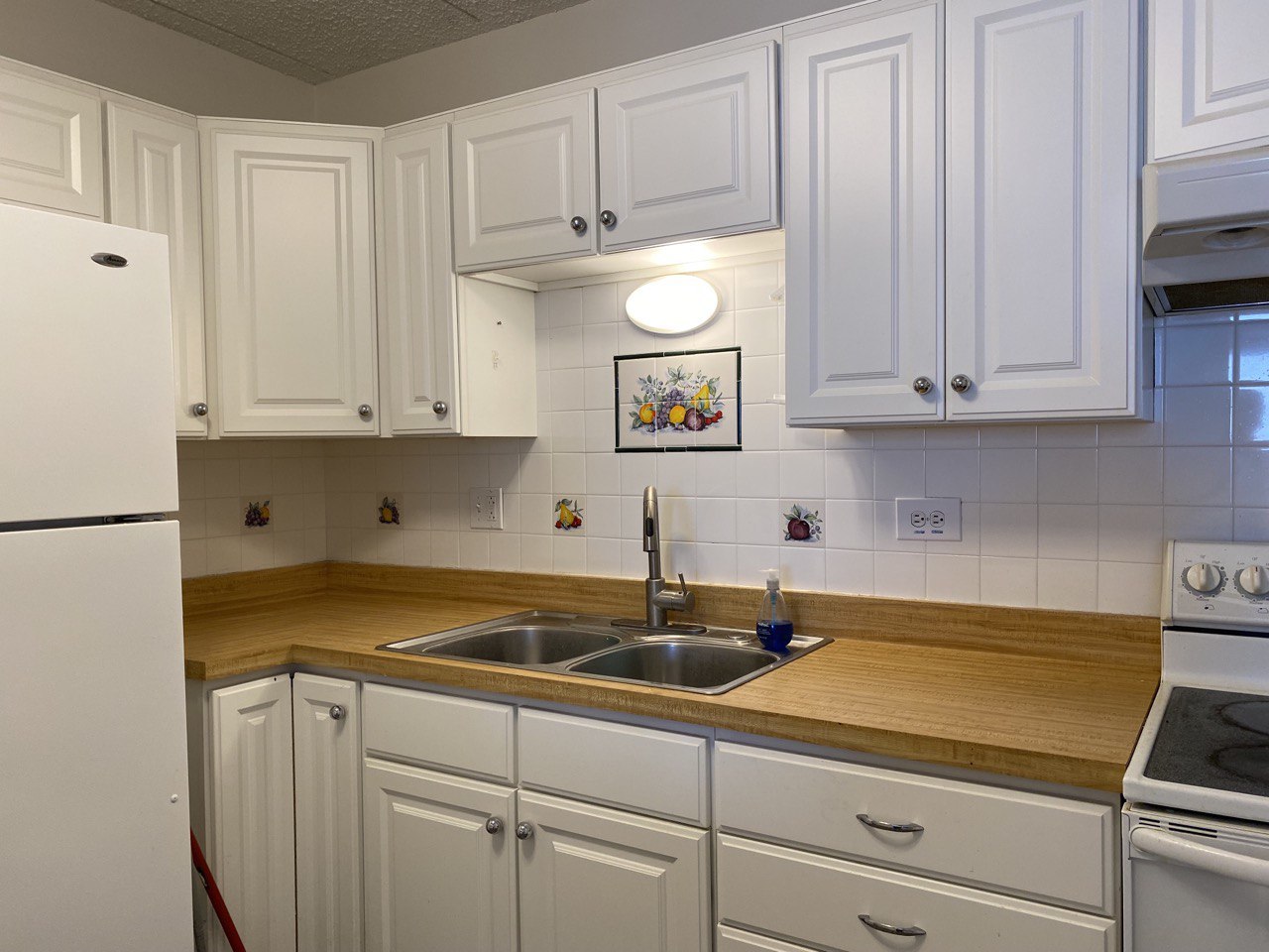 9128 West Terrace Drive, Unit 4B Niles, IL 60714 - Photo 7 of 24 a kitchen with stainless steel appliances granite countertop a sink a stove and white cabinets
