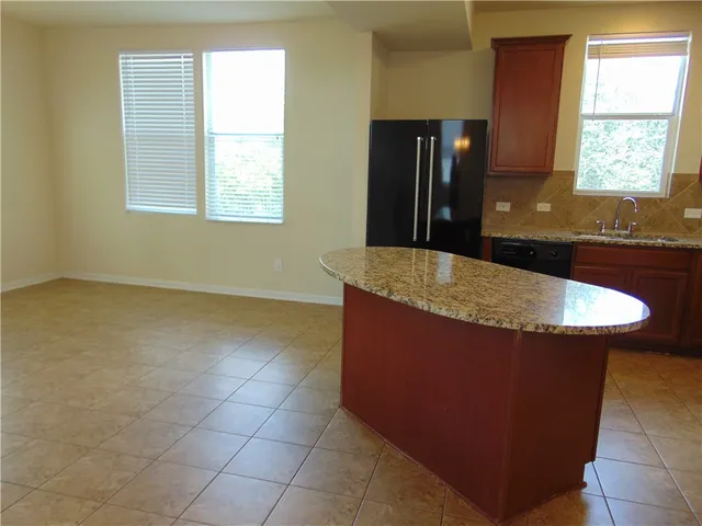 a kitchen with granite countertop a sink a window and stainless steel appliances