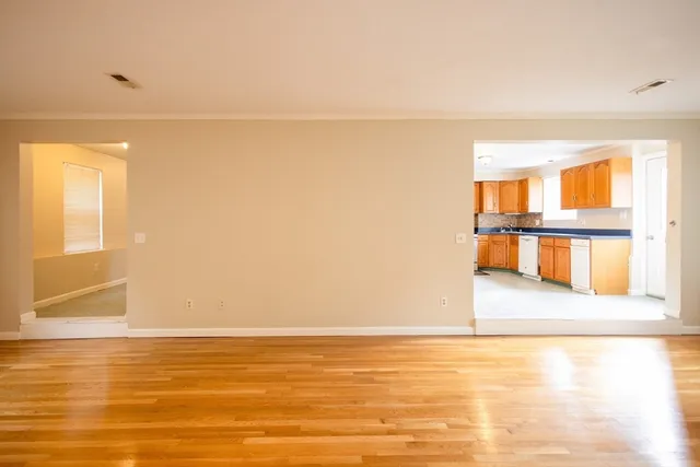 a view of a room with wooden floor and a large window