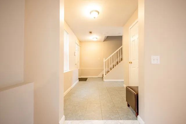a view of hallway with stairs and wooden floor