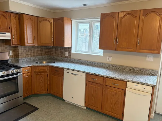 a kitchen with granite countertop cabinets stainless steel appliances a sink and wooden floor
