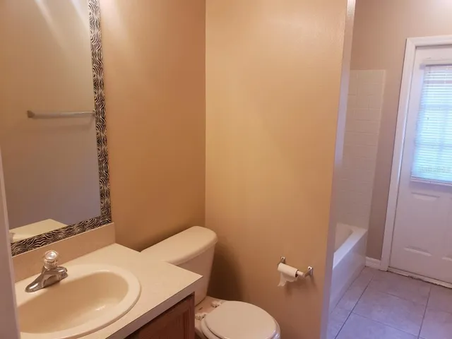 a bathroom with a sink a toilet and mirror