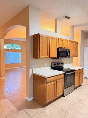a kitchen with stainless steel appliances granite countertop a stove a sink and a microwave