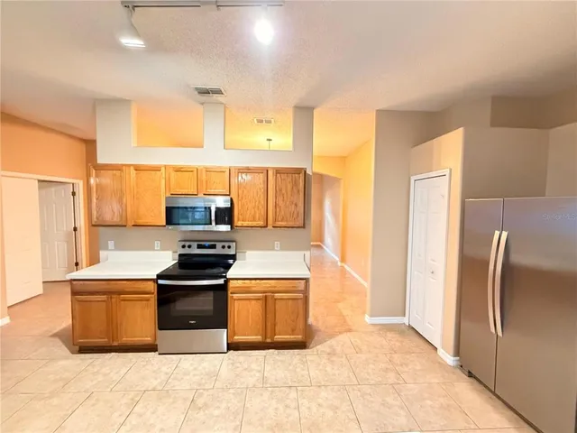 a kitchen with stainless steel appliances granite countertop a refrigerator and a stove