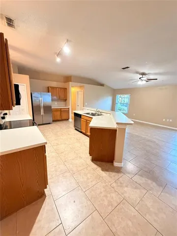 a view of a kitchen with kitchen island wooden cabinets and a counter top space