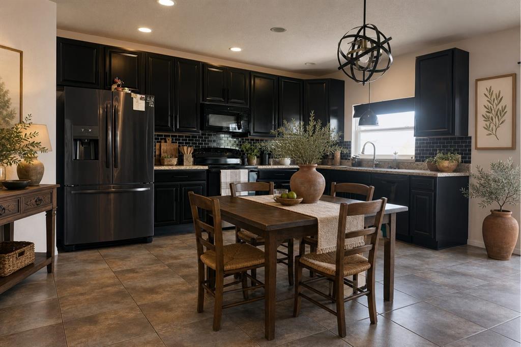3837 Spring Creek Road Dundee, FL 33838 - Photo 2 of 15 a kitchen with stainless steel appliances kitchen island granite countertop a refrigerator a stove a microwave oven a dining table and chairs with wooden floor